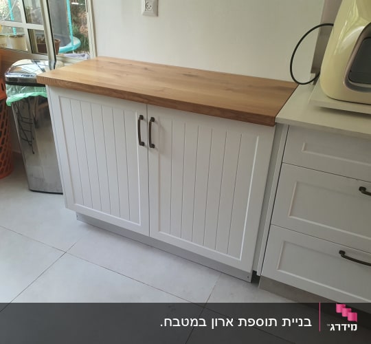 ארון מטבח עם משטח עץ ודלתות לבנות